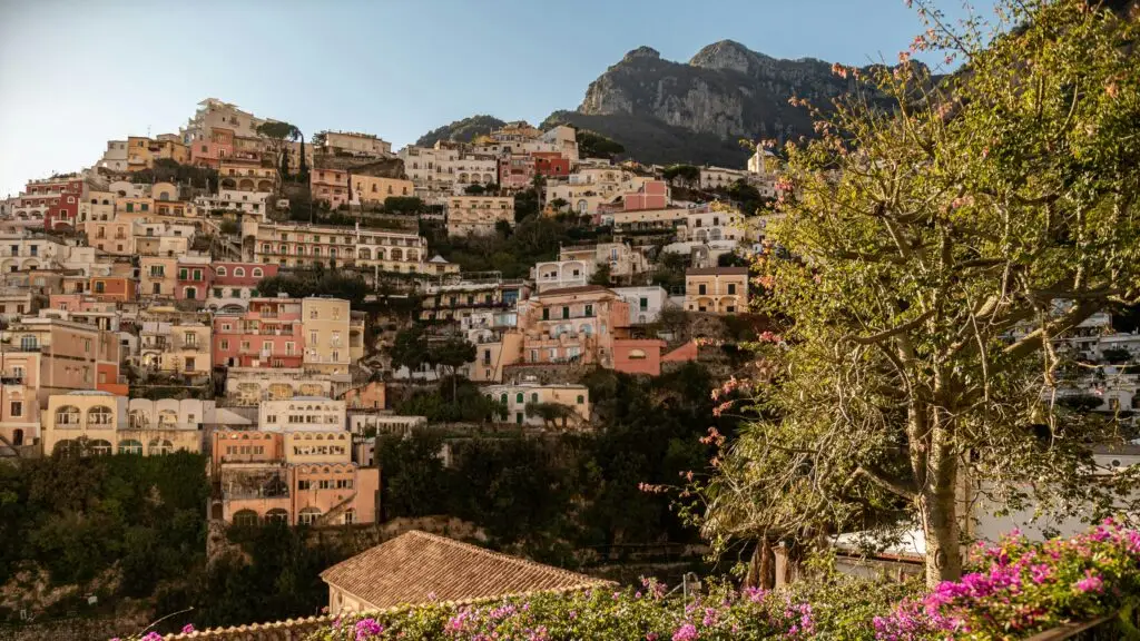 Scenic view of Positano's colorful buildings on the Amalfi Coast in Italy, bathed in warm sunlight.