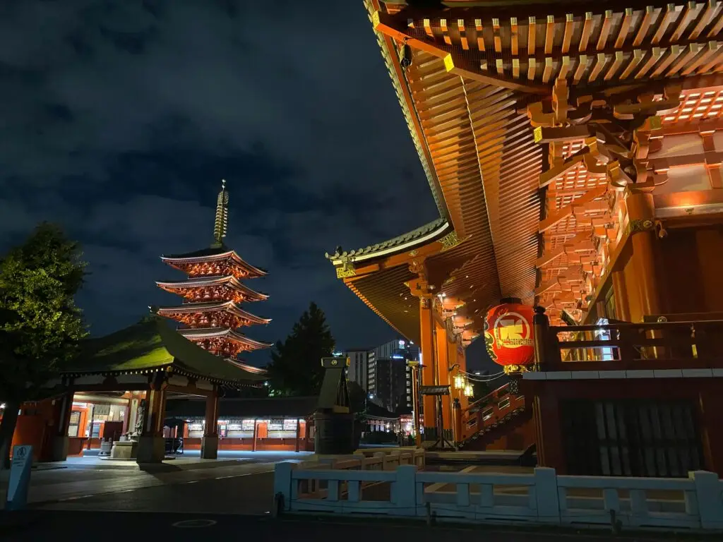 Night view of the illuminated Senso-ji Temple and pagoda in Tokyo, showcasing traditional Japanese architecture.